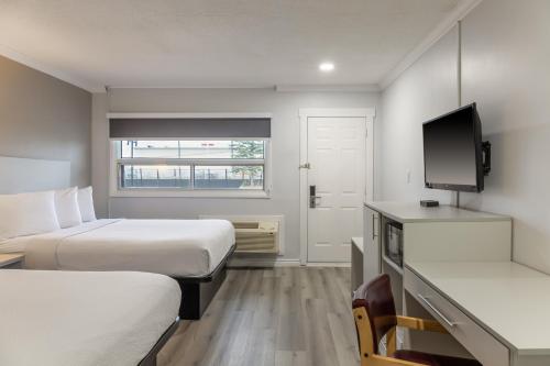 a hotel room with two beds and a flat screen tv at Motel 6 Cornwall Hwy 401 ON in Cornwall