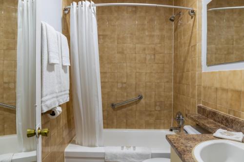 a bathroom with a shower and a tub and a sink at Motel 6 Cornwall Hwy 401 ON in Cornwall