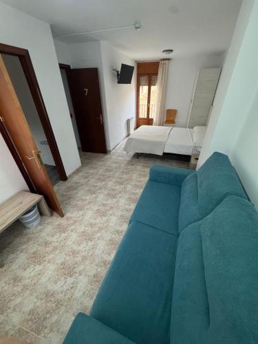 sala de estar con sofá azul y dormitorio en Hostal Marcela Berge, en Berge