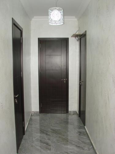 a hallway with two brown doors and a chandelier at Villa Royal House in Makhinjauri