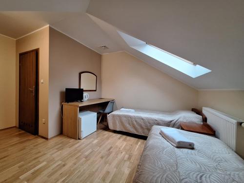a small room with two beds and a skylight at Aparthotel Xavito in Sanok