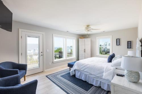 Jay CrestにあるNewly Listing Renovated bungalow steps from waterの白いベッドルーム(ベッド1台、窓2つ付)