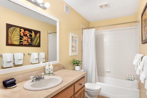 a bathroom with a sink and a tub and a toilet at Regency 620 in Koloa