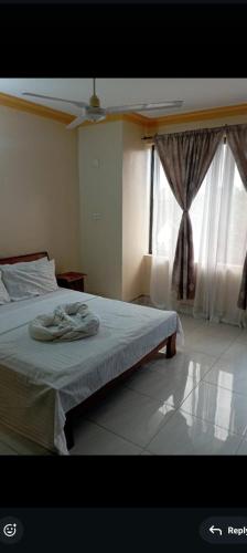 a bedroom with a bed and a large window at Nyali BnB Apartment in Mombasa