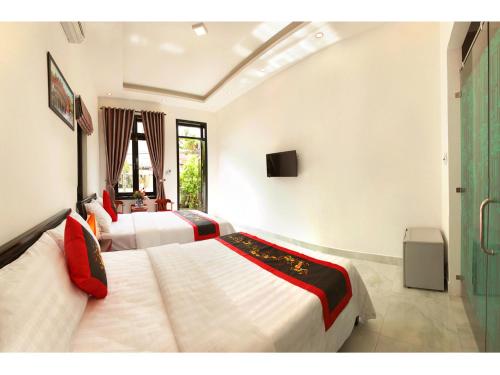 a hotel room with two beds and a television at Sunny Garden Homestay in Hoi An