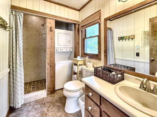 a bathroom with a toilet and a sink and a mirror at Karma Cabin in Scaly Mountain
