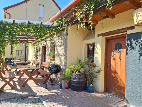 an outdoor patio with a wooden table and benches at Téged Vártunk Vendégház in Bakonyoszlop