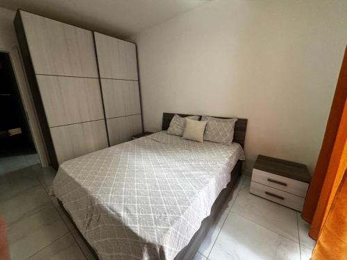a small bedroom with a bed and a cabinet at Tedds Cosy 2 bedroom Apartment in Tal-Pietà