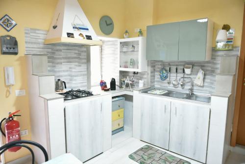 Una cocina con gabinetes blancos y un fregadero. en Casa vacanze da Anna, en Vietri