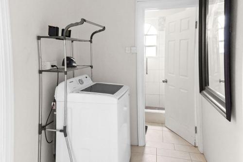 a white laundry room with a washing machine and a mirror at Oceanview• Mins to the Beach•Private BR Balconies in Moule à Chique