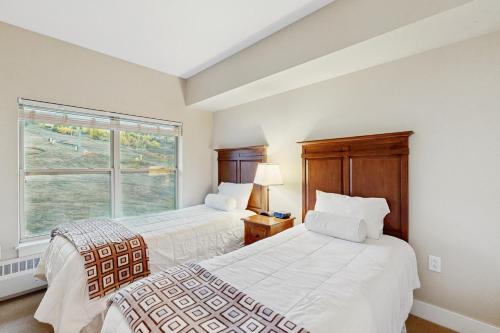 two beds in a room with a window at Base Camp One 403 in Granby