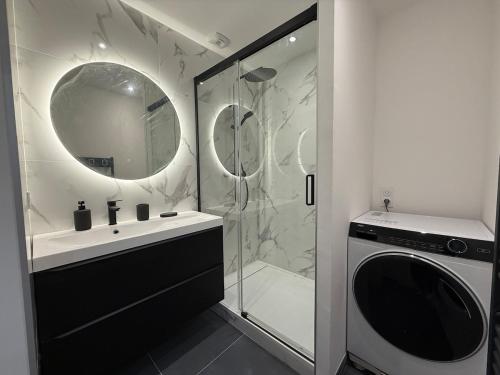 ein Badezimmer mit einer Dusche, einem Waschbecken und einer Waschmaschine in der Unterkunft T2 neuf marbre et or - écran géant - Netflix in LʼHermitage