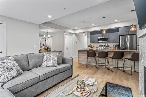 Una sala de estar con un sofá y una cocina. en Spacious 3BR Haven in Scenic Canmore, en Canmore