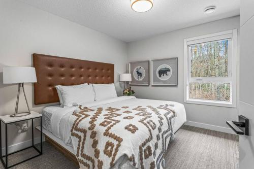 Un dormitorio con una cama grande y una ventana en Spacious 3BR Haven in Scenic Canmore, en Canmore