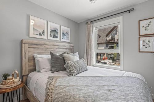 Un dormitorio con una cama grande y una ventana en New 3BR with Mountain Views Near DT Hot Tub and Pool, en Canmore