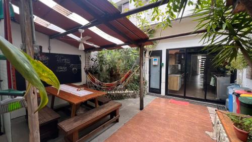a patio with a wooden table and a hammock at Casa Ibirapuera - Hospedagem in Sao Paulo