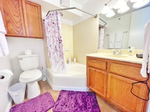a bathroom with a white toilet and a sink and a tub at Two Amazing Views in One Spacious Condo Getaway in Honolulu