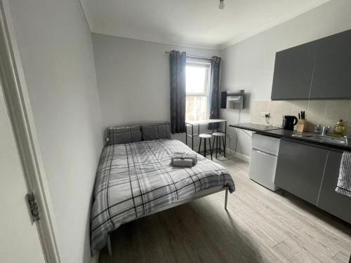 a small bedroom with a bed and a kitchen at The Oxford Avenue in Southampton