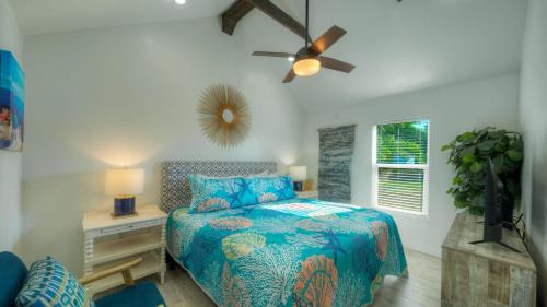 ein Schlafzimmer mit einem Bett und einem Deckenventilator in der Unterkunft Walk to Alister St Near Dining King Suite w Private Yard Fire Pit Casa Santori by AvantStay in Port Aransas