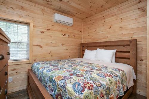 una camera da letto con un letto in una cabina di legno di Whiskey Duo 2 Cabins SidebySide HotTubs Firepit a Walnut Grove