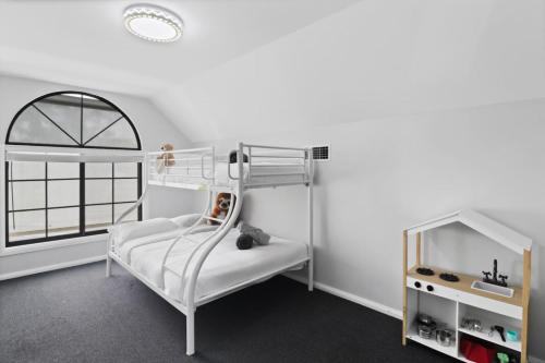 a white bedroom with a bunk bed and a window at Dora Creek Escape with Pool and Spa in Dora Creek