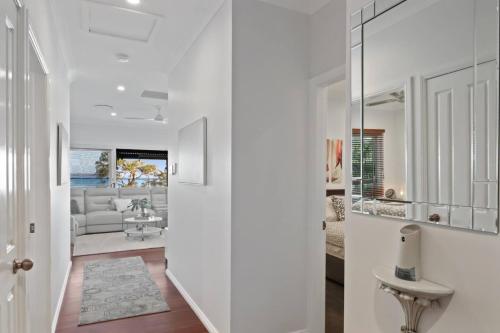 a white hallway with a living room with a couch at Bayview Bliss Brightwaters in Morisset East
