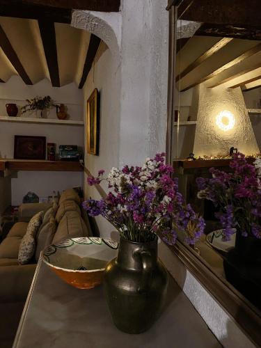 a living room with a vase with purple flowers on a table at La Casa de Dori in Beteta