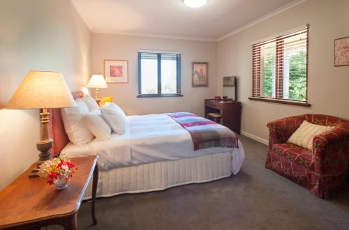 a bedroom with a bed and a table and a chair at Boyanda at Ferny Creek in Ferny Creek