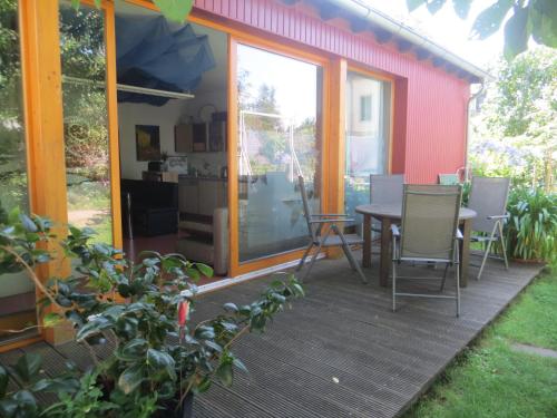 a house with a deck with a table and chairs at Gartenhaus Klotzsche in Dresden