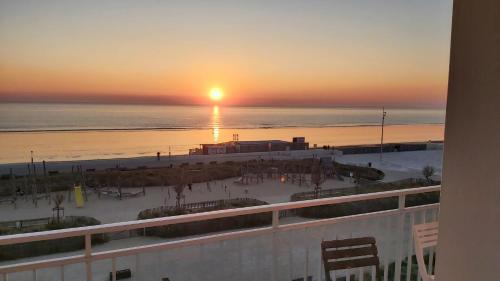 einen Blick auf den Strand bei Sonnenuntergang vom Balkon aus in der Unterkunft Les flots bleus face à la mer in Notre-Dame-de-Monts