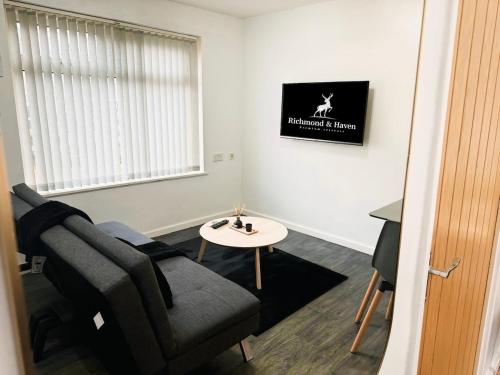 a living room with a chair and a table at Cosy 1 bed flat, sleeps 4, free parking in Bradford