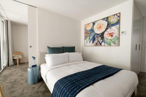 a bedroom with a bed with a painting on the wall at Chic Seddon Retreat Near the CBD in Seddon