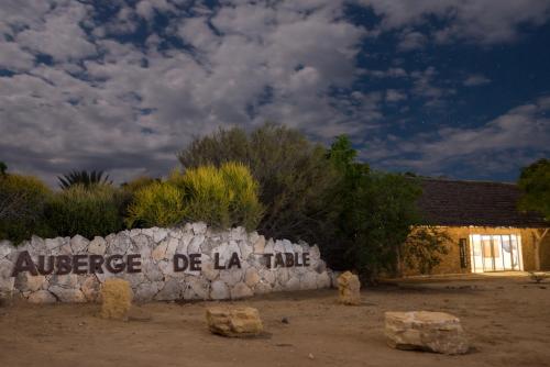 a stone wall with a sign that reads audience de la time at Auberge de la Table in Toliara