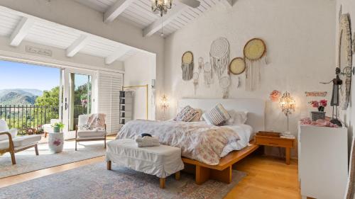 ein Schlafzimmer mit großem Bett und Balkon in der Unterkunft Private Malibu Escape w Guest House Fire Pits Mountain Views The Malibu Retreat by AvantStay in Monte Nido