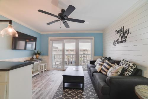 a living room with a couch and a ceiling fan at Pool and Direct Beach Access Corpus Christi Escape in Corpus Christi