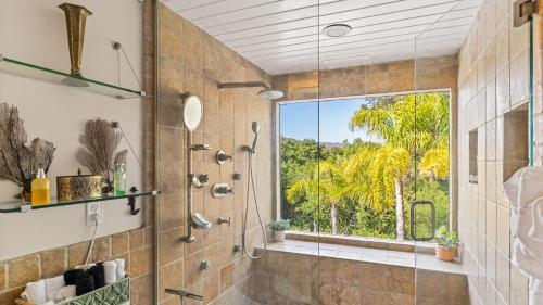ein Badezimmer mit einer Glasdusche mit Fenster in der Unterkunft Private Malibu Escape w Guest House Fire Pits Mountain Views The Malibu Retreat by AvantStay in Monte Nido