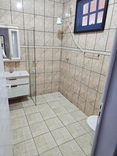 a bathroom with a shower with a toilet and a sink at Pousada CASA BELA mar in Itanhaém