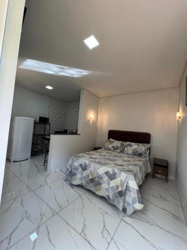 1 dormitorio con 1 cama en una habitación con suelo de mármol en Chalé Roda Dágua C, en Caparaó Velho