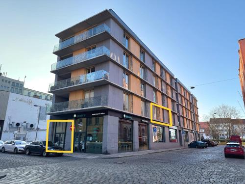 a tall building on a city street with cars parked at Veleslaveenka in Plzeň