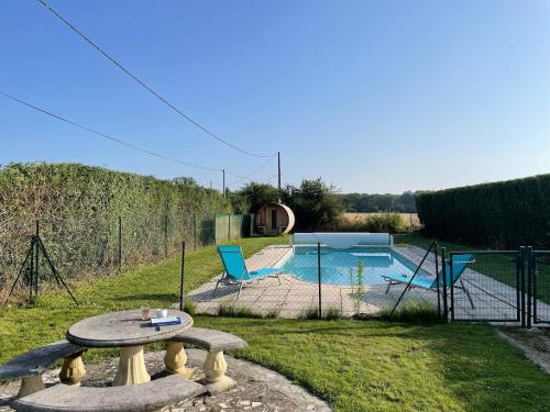 einen Hinterhof mit einem Tisch und einem Pool in der Unterkunft Family Cottage 4-6p with AC, Pool and Sauna in Pruniers