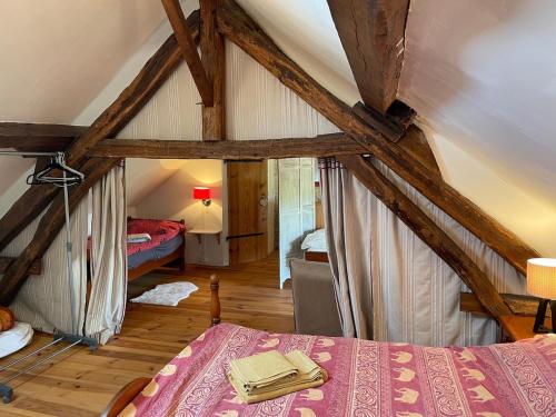 ein Schlafzimmer mit einem Bett in einem Zimmer mit Holzboden in der Unterkunft Family Cottage 4-6p with AC, Pool and Sauna in Pruniers