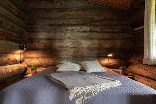 une chambre avec un lit dans une cabane en rondins dans l'établissement Charming Cottage on a Fell, à Pudasjärvi