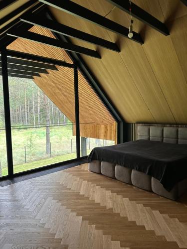 a bedroom with a bed in a room with windows at Chata w Puszczy Nowa Łuka in Łuka