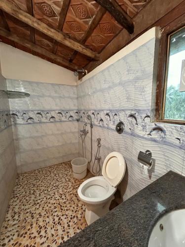 a bathroom with a toilet and a sink at Maria Paulo Guest House Bar and Restaurant in Agonda