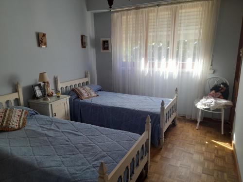 a bedroom with two twin beds and a window at La Casa de Oli in Chascomús