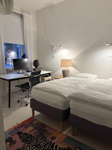 a bedroom with two beds and a desk with a computer at Apartament Dominic in Sopot