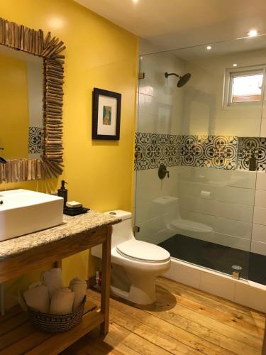 een badkamer met een wastafel, een toilet en een douche bij Turtle Beach Sanctuary, Utila in Utila