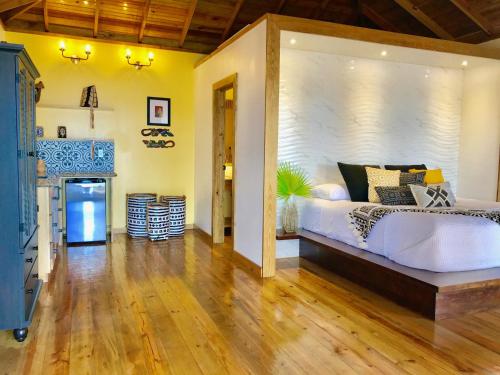 een slaapkamer met een groot wit bed en een open haard bij Turtle Beach Sanctuary, Utila in Utila