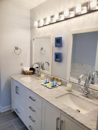 a bathroom with two sinks and two mirrors at Coral Crest in Hampstead