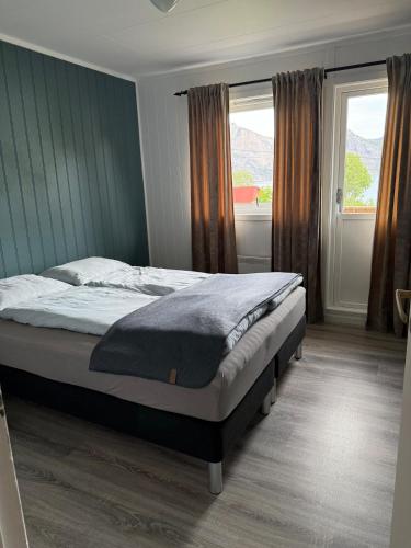 ein Schlafzimmer mit einem Bett und einem Fenster in der Unterkunft Solstad in Senja